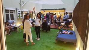 Un evento interior con alfombra verde, mesas y sillas.