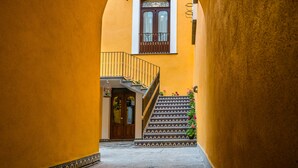 Une ruelle étroite avec un escalier menant à l’entrée d’un immeuble.