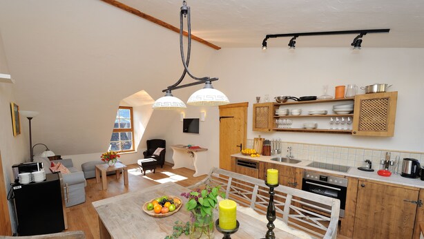 A spacious living area with a dining table, kitchen, and seating arrangements. - Heritage Dürnstein (Durnstein)