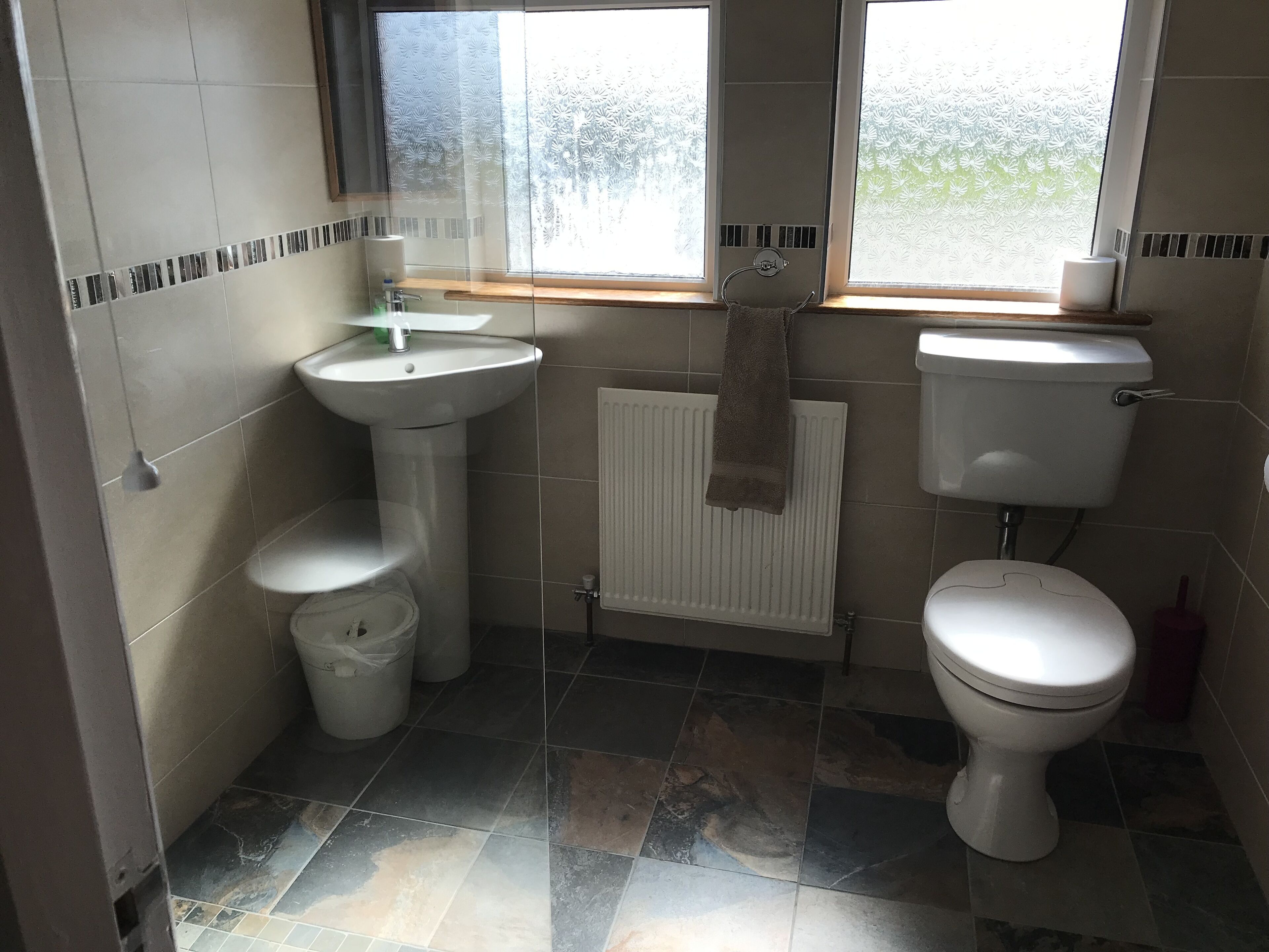 Un baño con inodoro, lavamanos y radiador.
