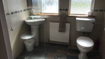 Un baño con inodoro, lavamanos y radiador.