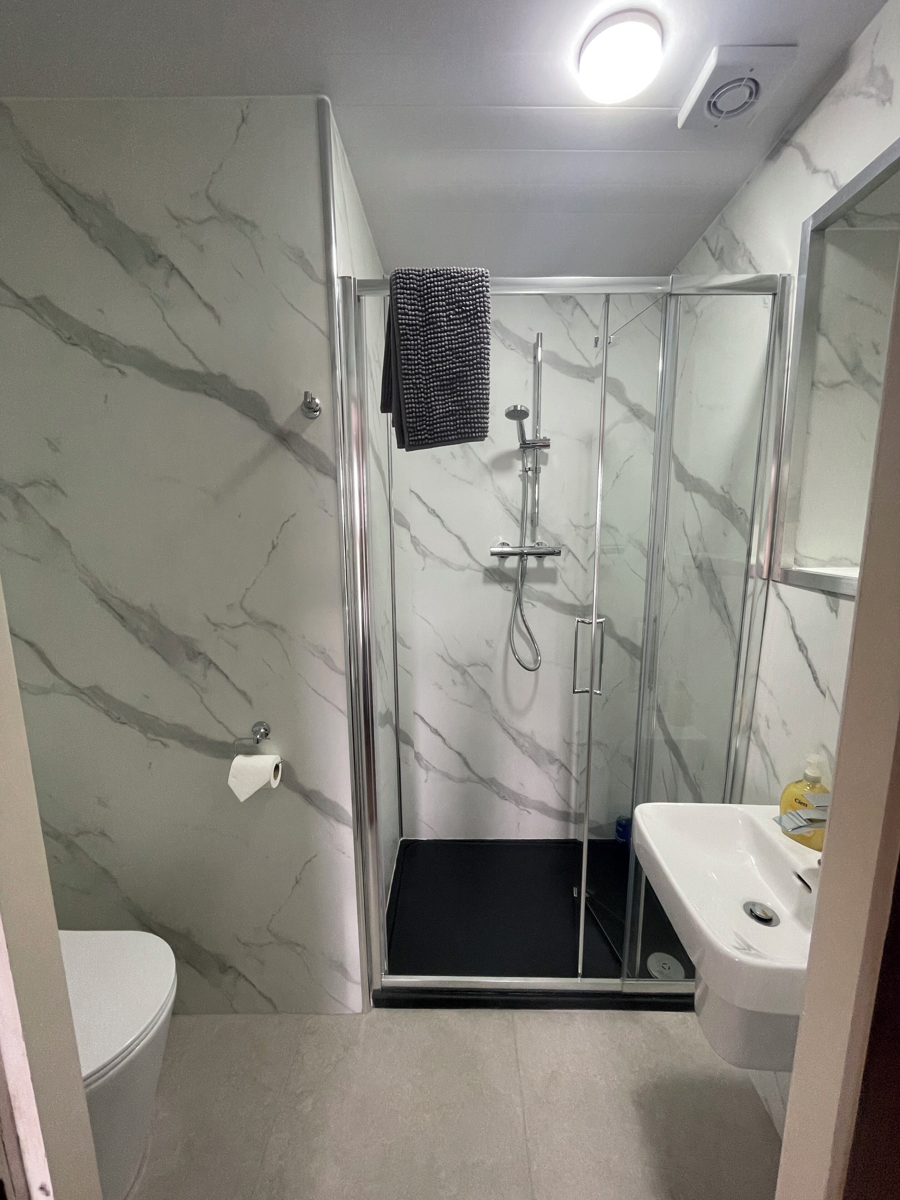 A bathroom with a shower, toilet, and sink.
