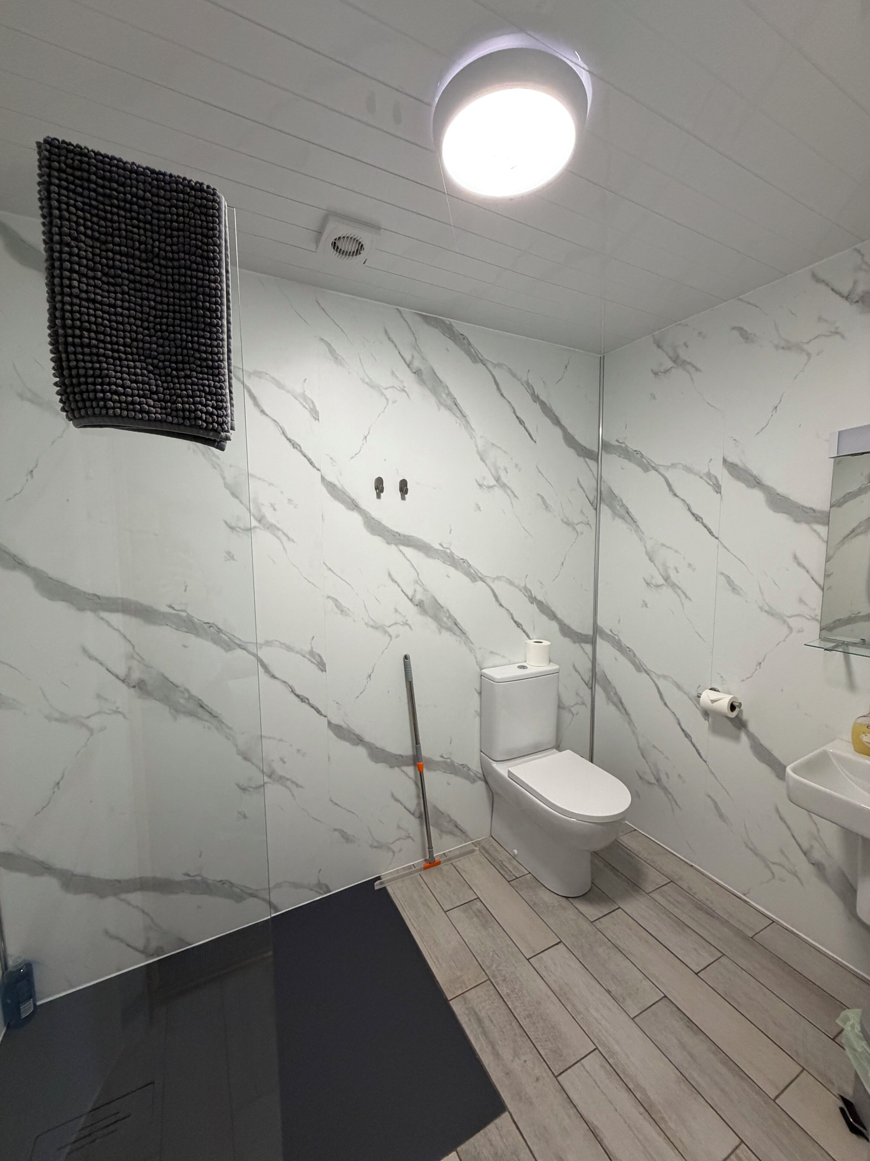 Ein Badezimmer mit Toilette, Waschbecken und Duschbereich.