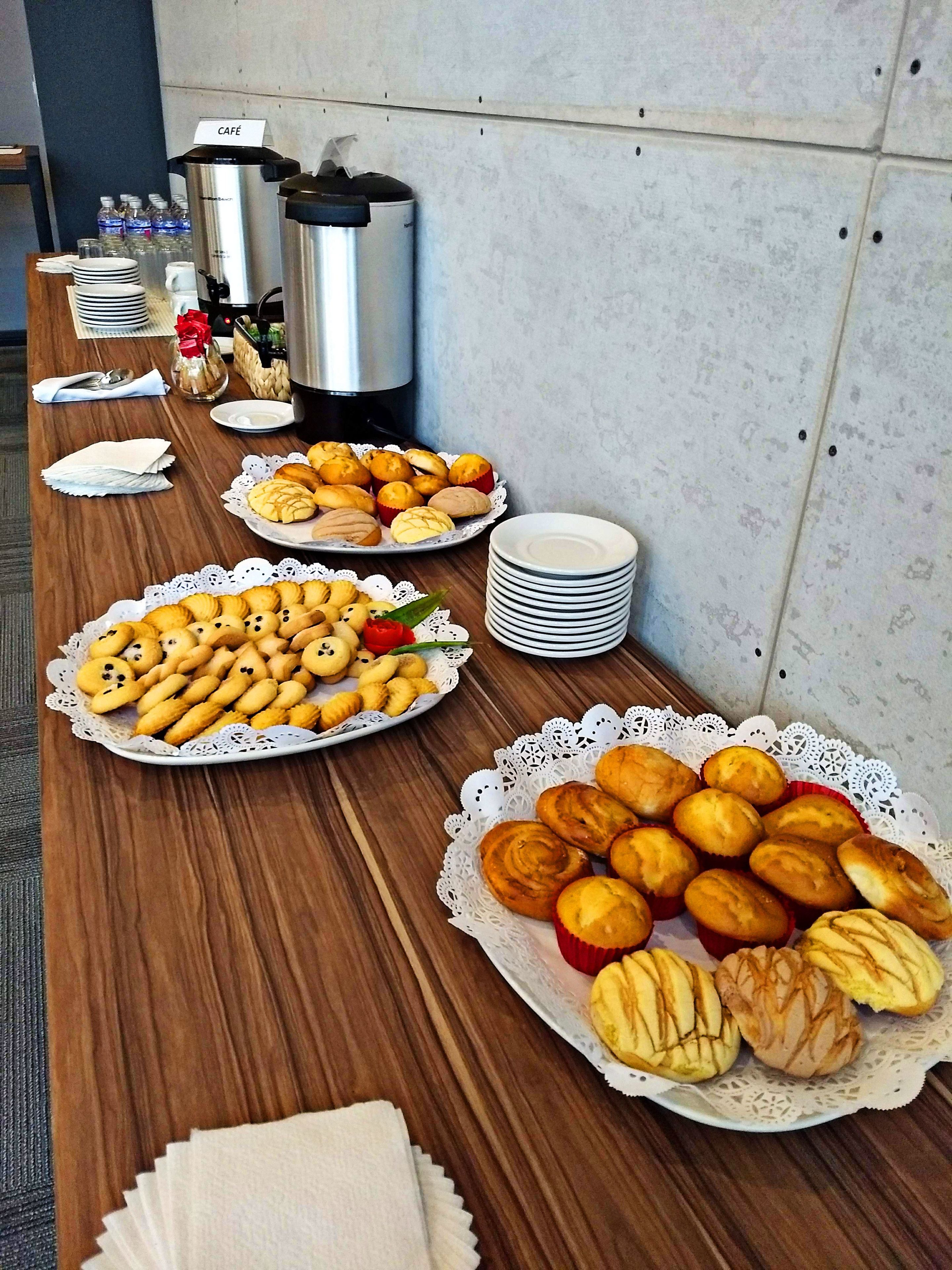 A buffet table with various pastries and a coffee station.