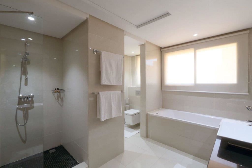 Une salle de bain moderne dotée d’une douche à parois de verre, d’une baignoire et de toilettes.