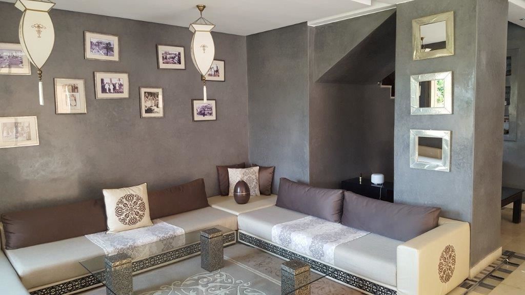 A modern living room with a sectional sofa, a coffee table, and framed pictures on the wall.