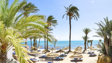 On the beach, white sand, sun-loungers, beach umbrellas