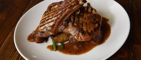 A plate with grilled meat, potatoes, and green beans.