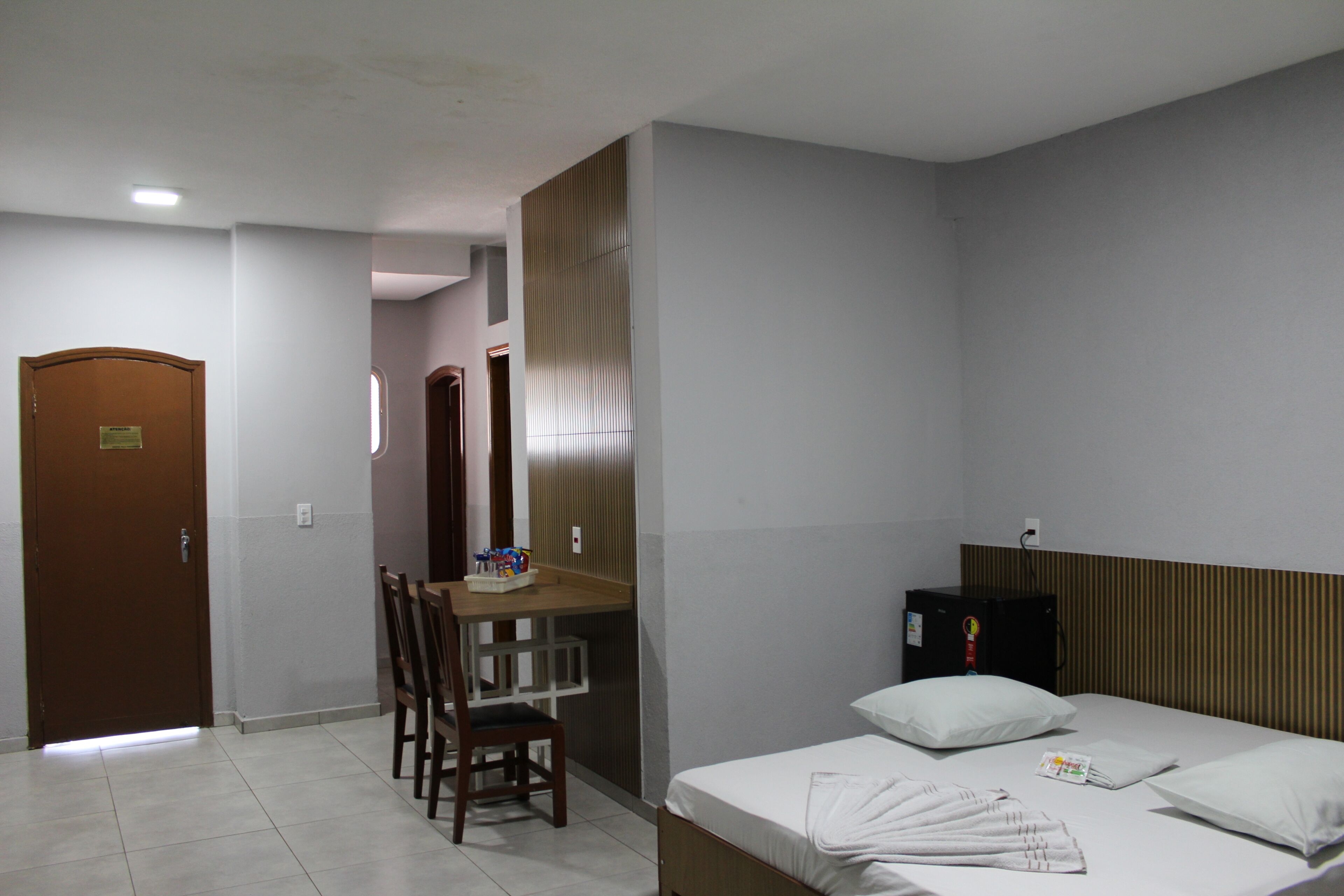 Une chambre d’hôtel avec un lit, un bureau et une chaise.
