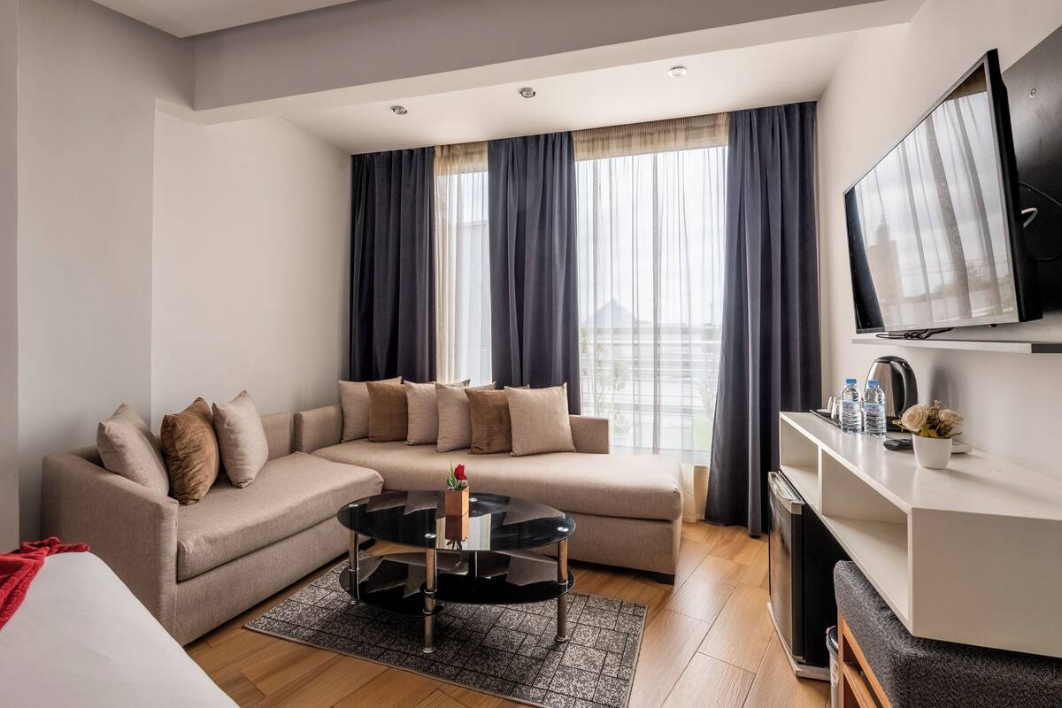 A modern living room with a sofa, a coffee table, and a TV.