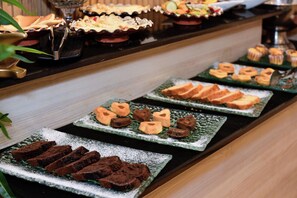 A buffet with various desserts including brownies, heart-shaped cookies, and pastries. - Hôtel Le Musée (Rabat)