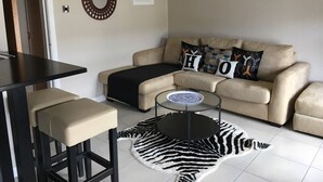 A living room with a sofa, a coffee table, and a zebra rug. - Belfast House (Cookstown)