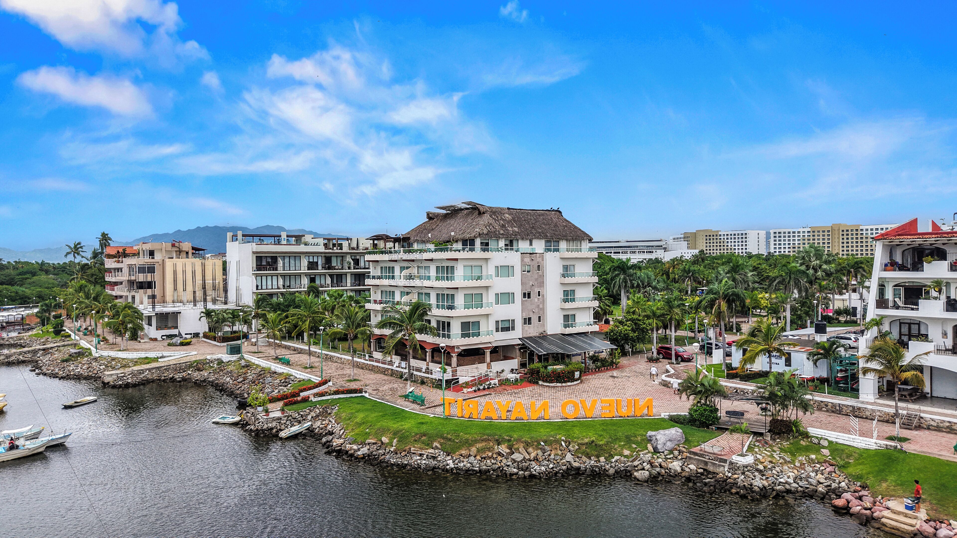 Ein Küstenhotel mit mehreren Gebäuden, einer Marina und blauem Himmel.