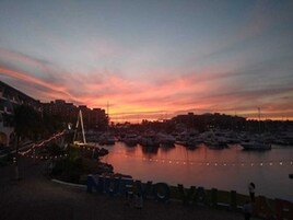 Un puerto deportivo con barcos amarrados de noche, un puente y la palabra "NUENOVALL" a la vista.