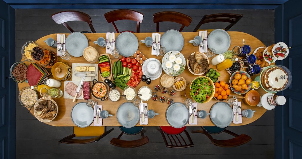 A dining table set with various dishes, utensils, and glasses.