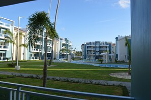 Ein modernes Hotel mit mehreren Etagen, einem Pool und Palmen.
