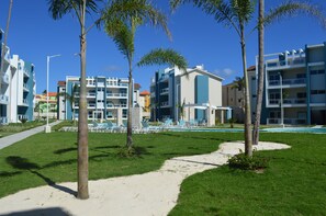 Ein Resort mit mehrstöckigen Gebäuden, einem Swimmingpool und Palmen.