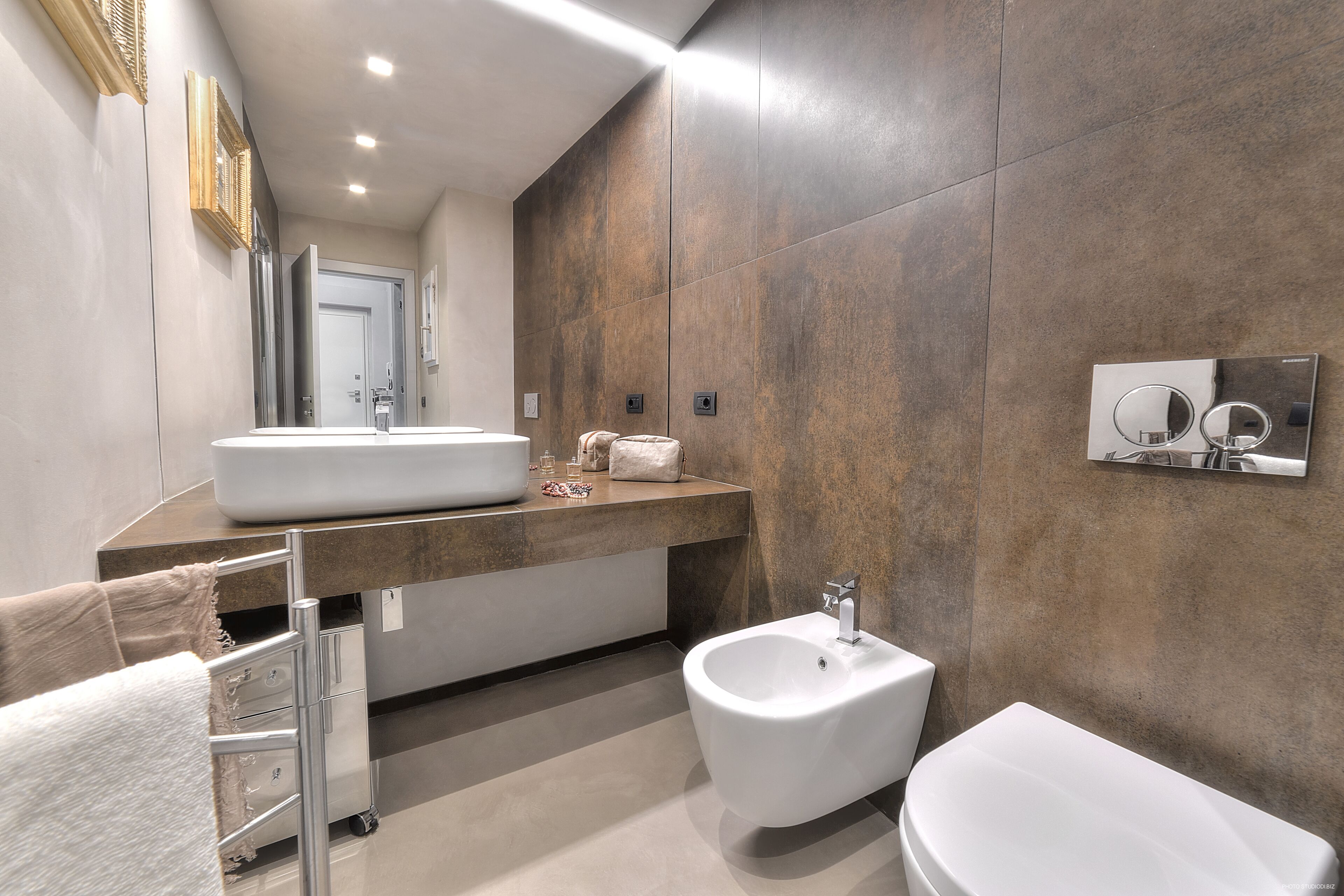 Une salle de bain moderne avec un grand lavabo, un bidet et un miroir.