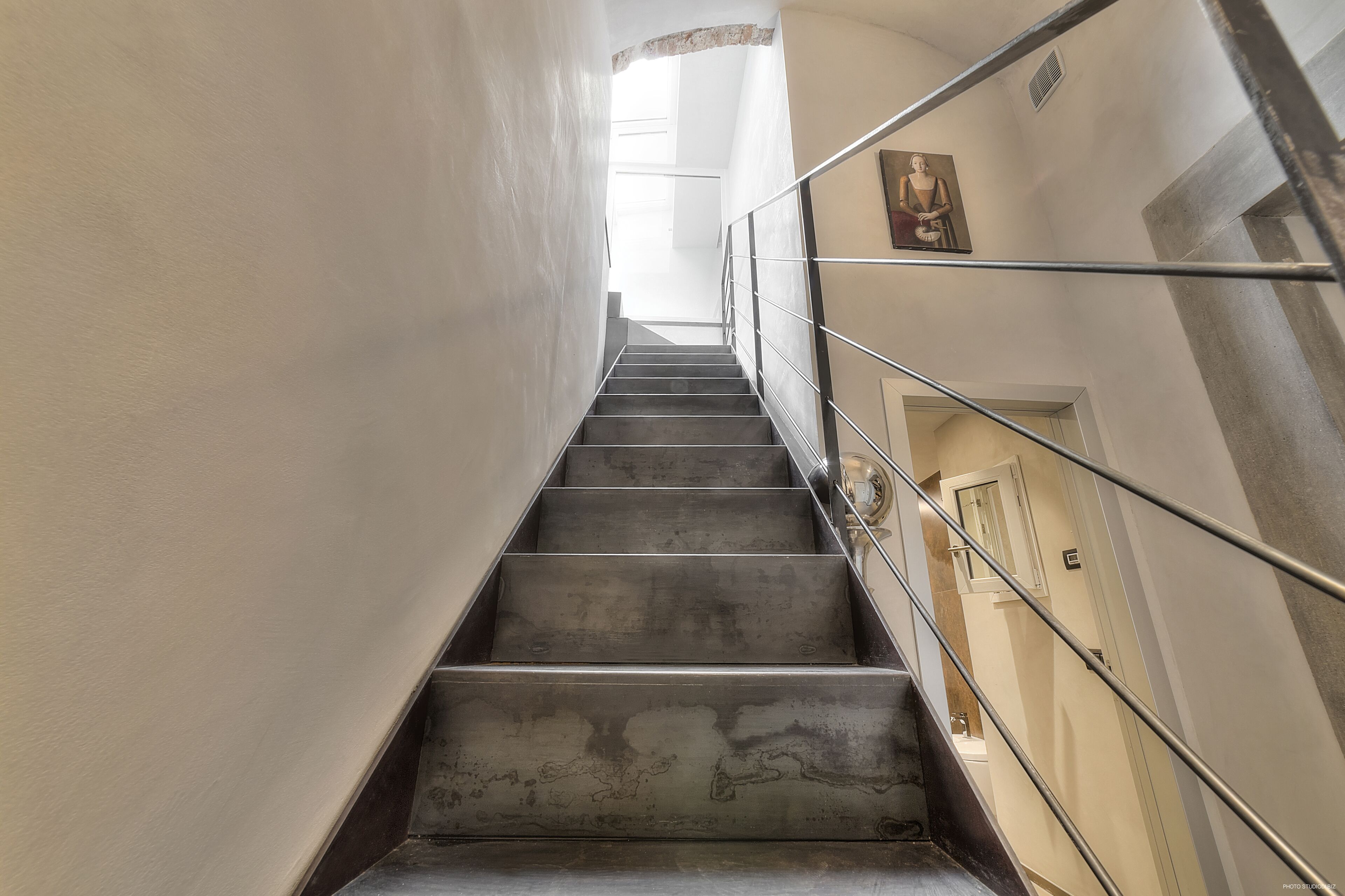 Un escalier avec des rampes en métal menant à l’étage supérieur.