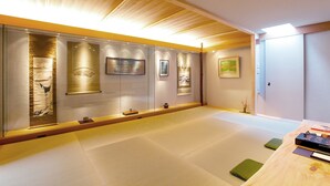 Een traditionele Japanse kamer met tatami vloeren, schuifdeuren en kunstwerken aan de wanden.