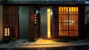Een modern gebouw met een traditionele Japanse entree, compleet met schuifdeuren en een bord.