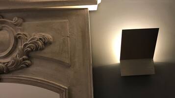 Parede com luminária e moldura decorativa.