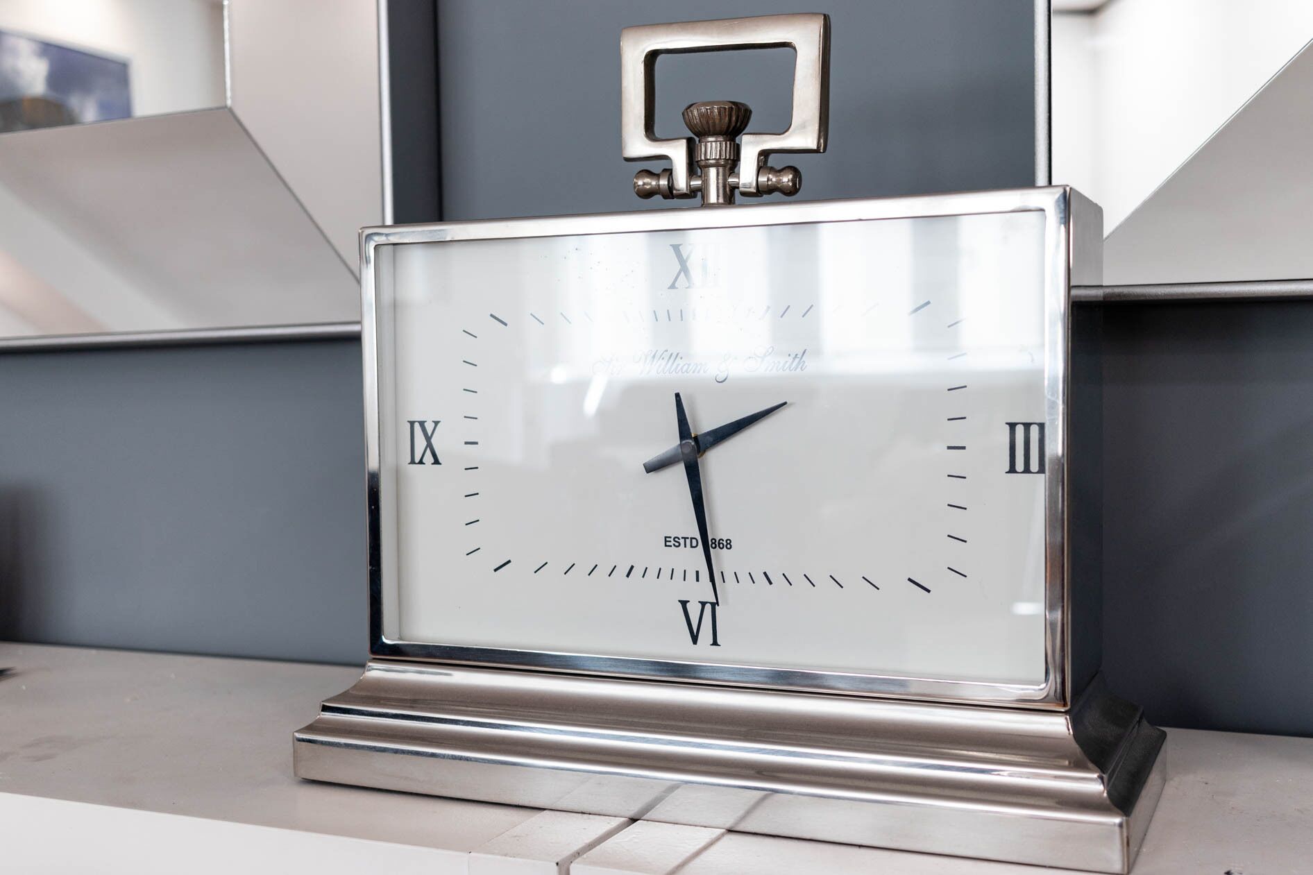 Eine Wanduhr mit römischen Ziffern und der Jahreszahl ESTD 1868.