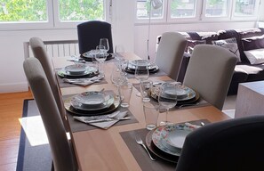 Una mesa para comer preparada con platos, vasos y cubiertos.