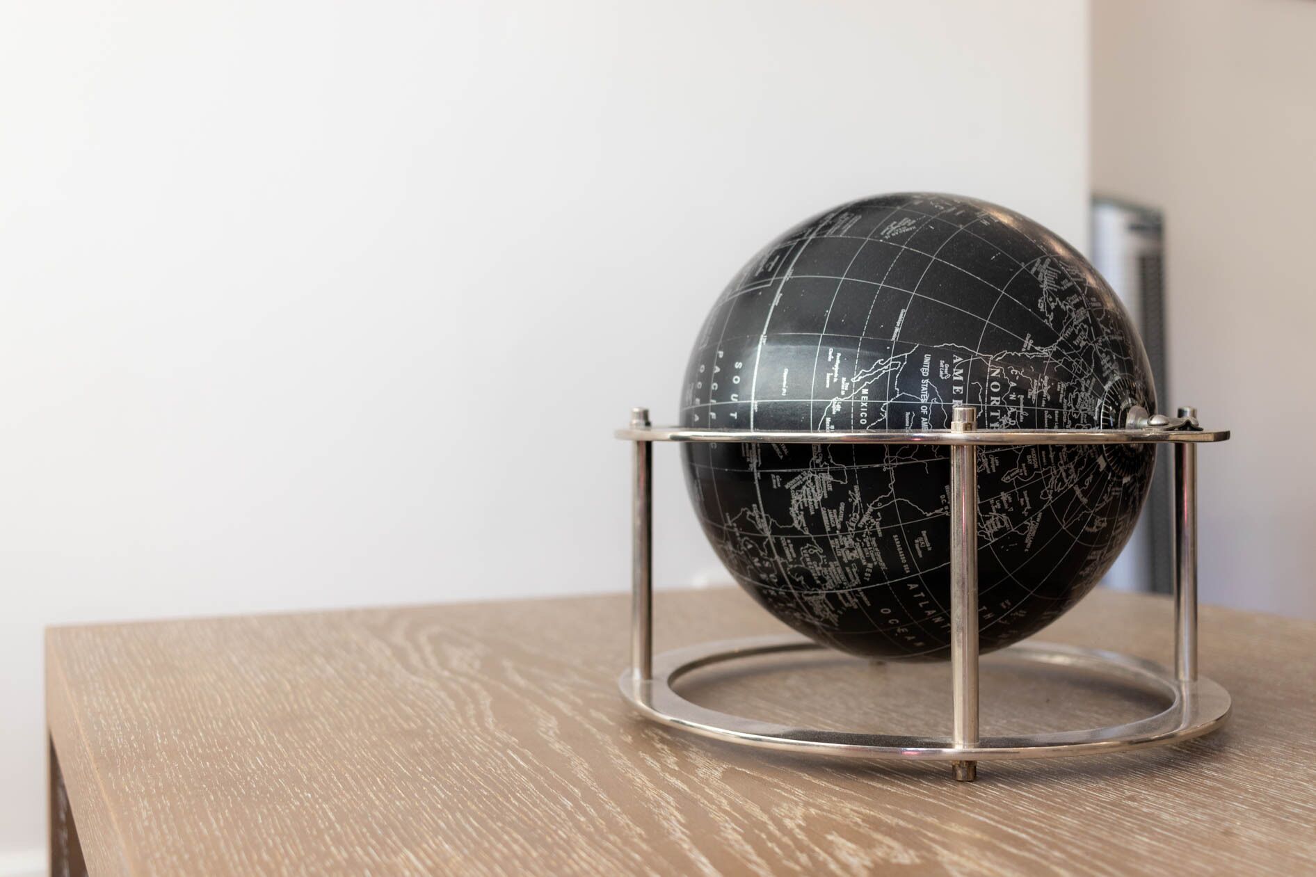 Un globo negro con líneas de cuadrícula blancas sobre una mesa de madera.