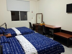 A bedroom with two beds, a desk, a chair, and a bench.