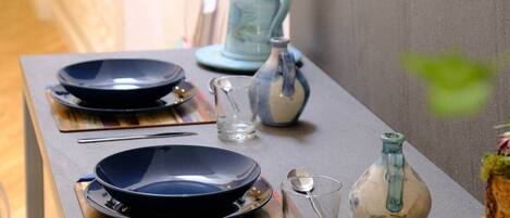 A dining table with plates, cutlery, and glasses, set against a neutral wall.