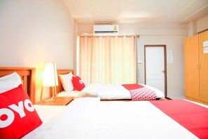 A hotel room with two beds, a nightstand with a lamp, an air conditioning unit, and a wardrobe. - OYO 349 Aroonrung House (Nonthaburi)