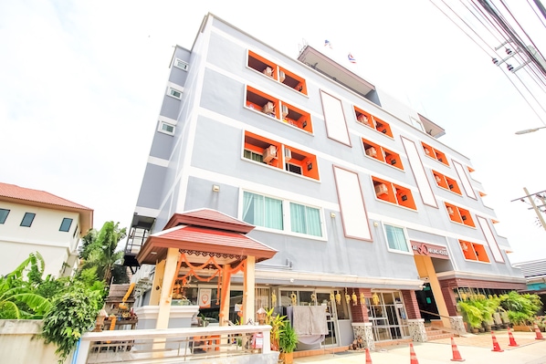 A multi-story hotel with a modern design, featuring balconies with orange railings and a covered entrance area. - OYO 349 Aroonrung House (Nonthaburi)