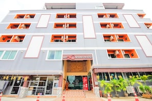 A multi-story building with a modern design, featuring a prominent entrance with steps, a signboard, and multiple balconies with air conditioning units. - OYO 349 Aroonrung House (Nonthaburi)