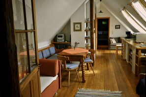 Relax in this inviting room with a sofa, dining table, and window offering a view of the outside.