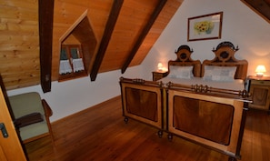 Relax in a serene bedroom with a large bed, nightstands, and a framed artwork, surrounded by lush greenery.