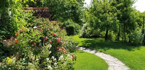 Stroll through a lush garden, surrounded by vibrant flowers and trees, along a winding stone pathway.