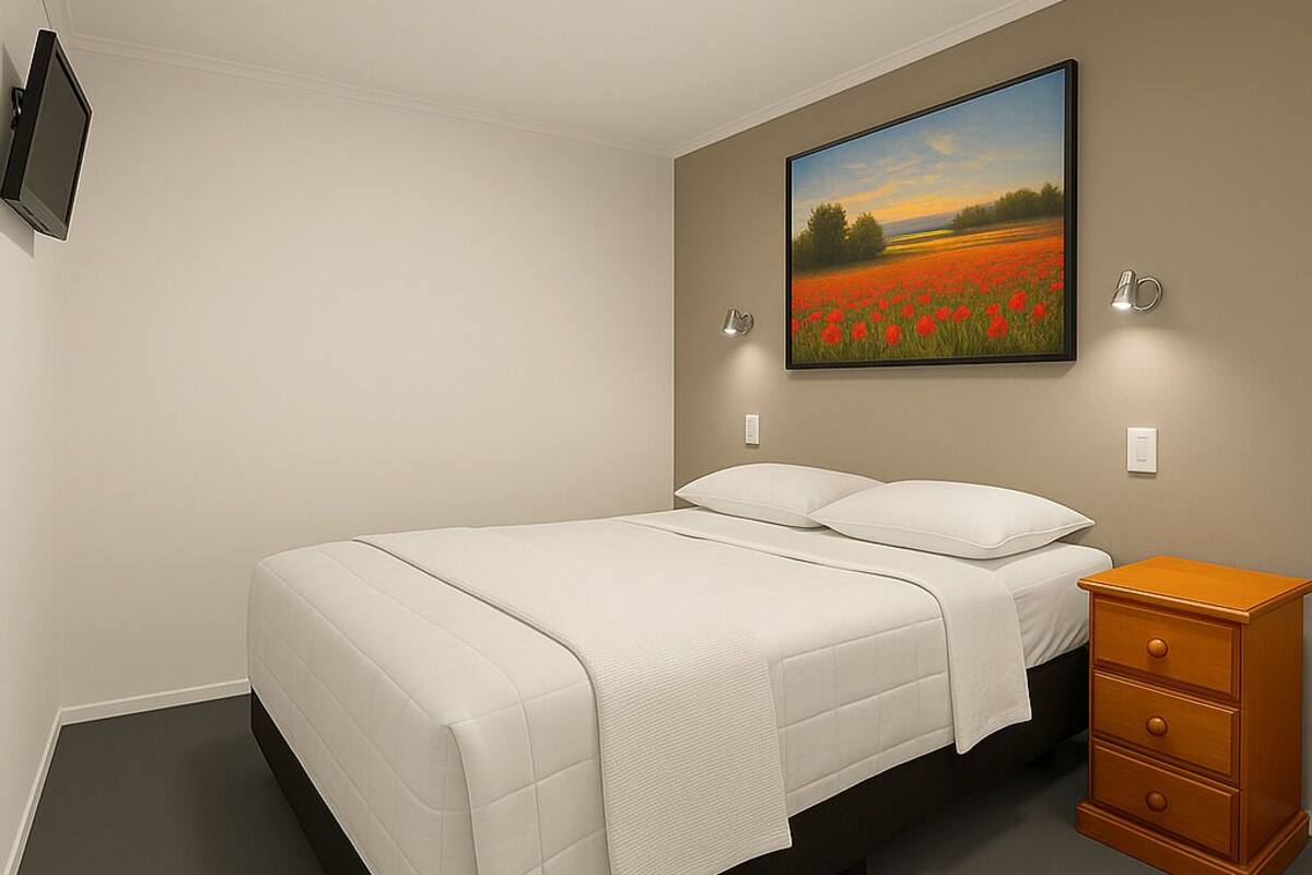 A bedroom with a bed, a nightstand, a painting, and a wall-mounted TV.