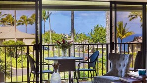 A balcony with a table, chairs, and a decorative vase. - Amazing View ~ Amazing Price ~ Amazing Location  (Princeville)