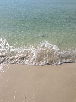 Una playa con agua cristalina y olas suaves.