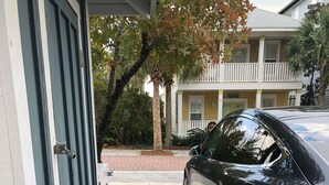 A car parked in a driveway with a charging cable connected to a charging station.