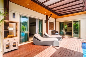 A wooden deck with two lounge chairs and a built-in shelf unit. - Niche Villas by TropicLook (Rawai)