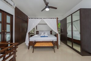 A bedroom with a large bed, a ceiling fan, and a wardrobe with mirrored doors. - Niche Villas by TropicLook (Rawai)