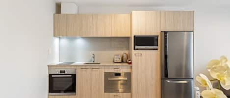 A modern kitchen with wooden cabinets, stainless steel appliances, and a built-in oven.