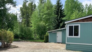 A gravel driveway leading to a green building with a white door and window. - Beautiful Cle Elum Getaway- Minutes to Skiing, Hiking, Suncadia (Cle Elum)