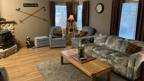 A cozy living room with a fireplace, a sofa, a chair, and a coffee table. - Beautiful Cle Elum Getaway- Minutes to Skiing, Hiking, Suncadia (Cle Elum)
