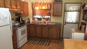 A kitchen with wooden cabinets, a stove, a sink, and a refrigerator. - Beautiful Cle Elum Getaway- Minutes to Skiing, Hiking, Suncadia (Cle Elum)
