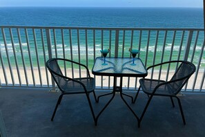 Un balcon avec deux chaises et une table, donnant sur l’océan.