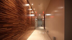 A corridor with a wooden panel wall and a polished floor, leading to a door at the end. - STAY GONGDAM  (Changwon)