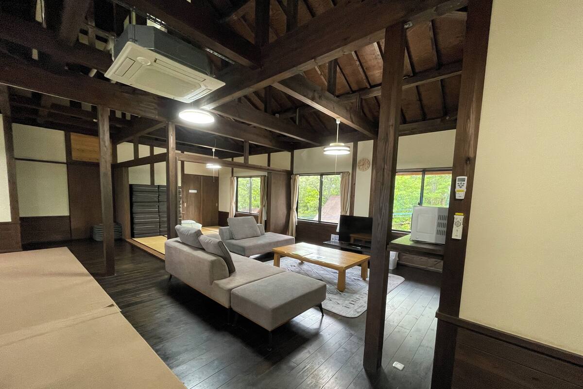 A traditional-style room with tatami mats, a low wooden table, and a sofa.